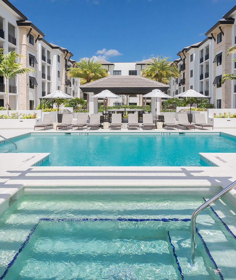 Architectural Land Design Commercial Landscape Project Portfolio: Naples Square Pool, Spa, and elegant walkways featuring tropical foliage